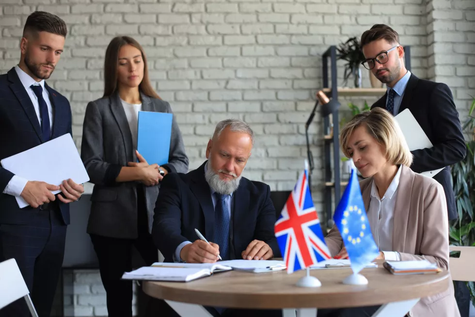 two-business-partners-signing-document-european-union-united-kingdom