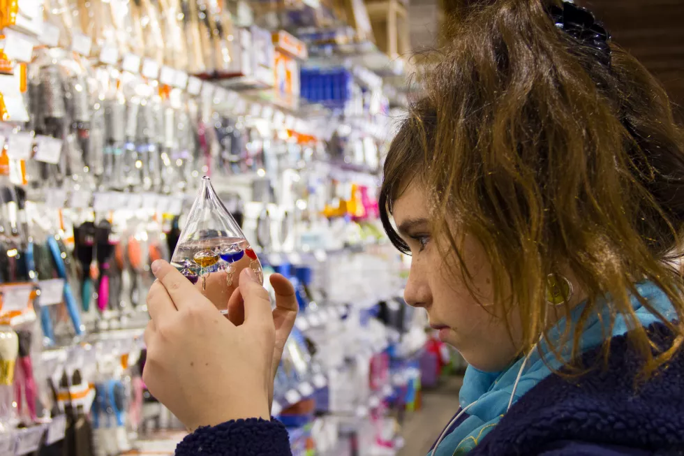 side-view-young-woman-looking-galileo-thermometer-store