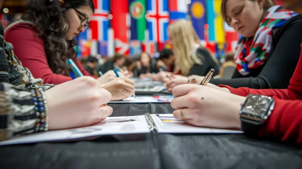 international-delegates-writing-notes-with-various-world-flags-background(1)