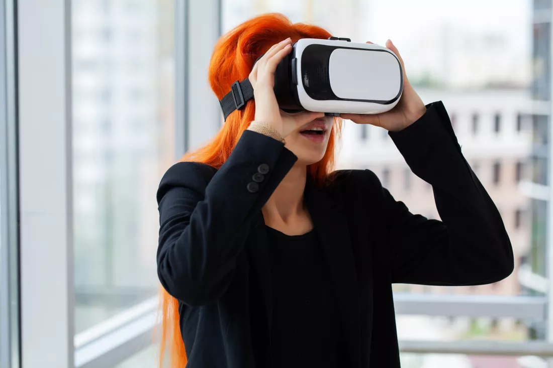 Kobieta zaklada gogle VR w nowoczesnym biurze