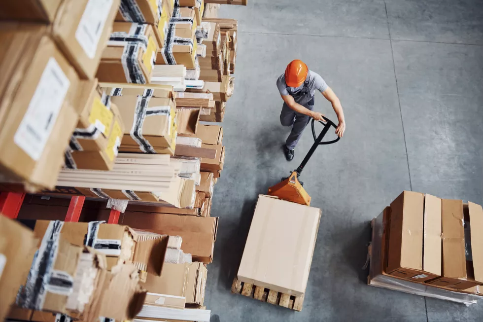 top-view-male-worker-warehouse-with-pallet-truck