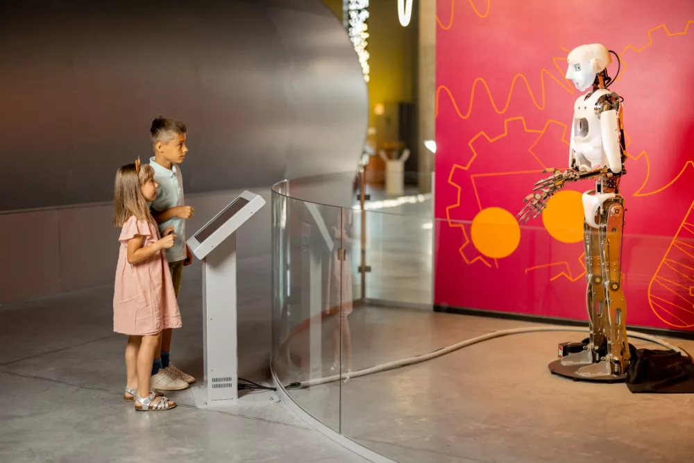 Dzieci przygladaja sie humanoidalnemu robotowi na wystawie w muzeum nauki