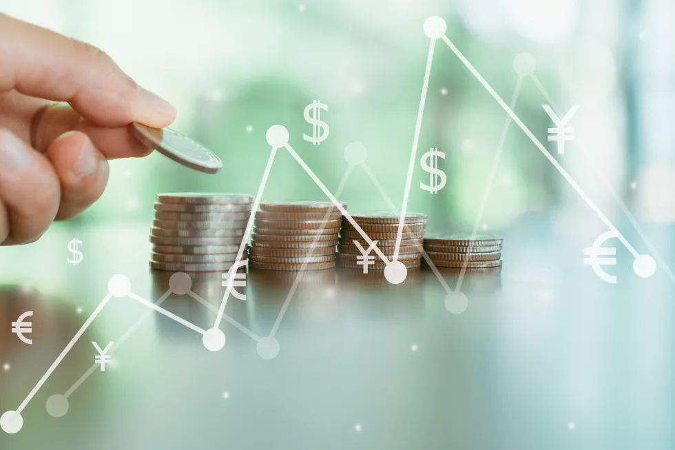cropped-hand-stacking-coins-table