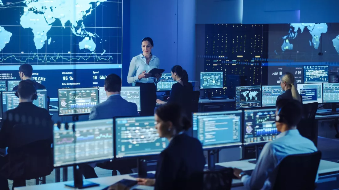 Zespół specjalistów pracuje przy monitorach w centrum monitoringu.