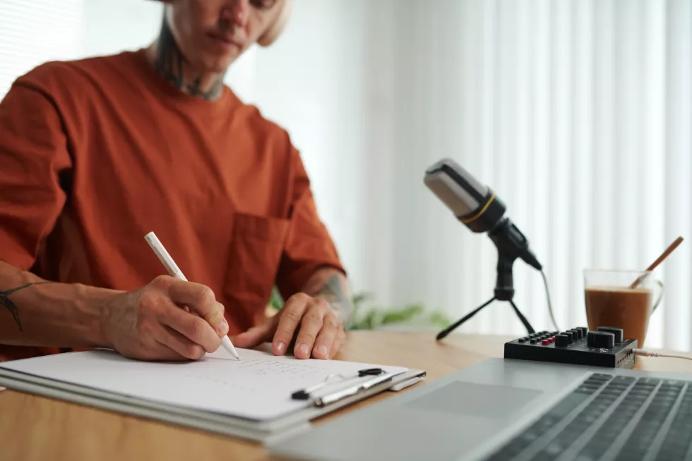 cropped-image-podcaster-writing-down-main-ideas-before-starting-record-podcast-blog