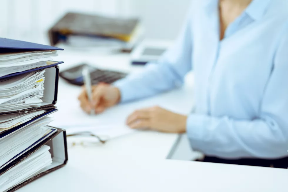 calculator-binders-with-papers-are-waiting-be-processed-by-business-woman-bookkeeper-back-blur-internal-audit-tax-concept