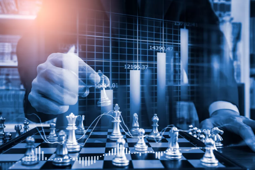 digital-composite-image-businessman-playing-chess-with-graph-desk