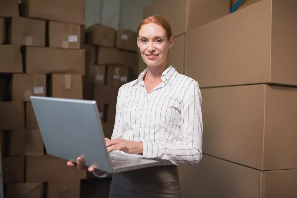 female-manager-using-laptop-warehouse