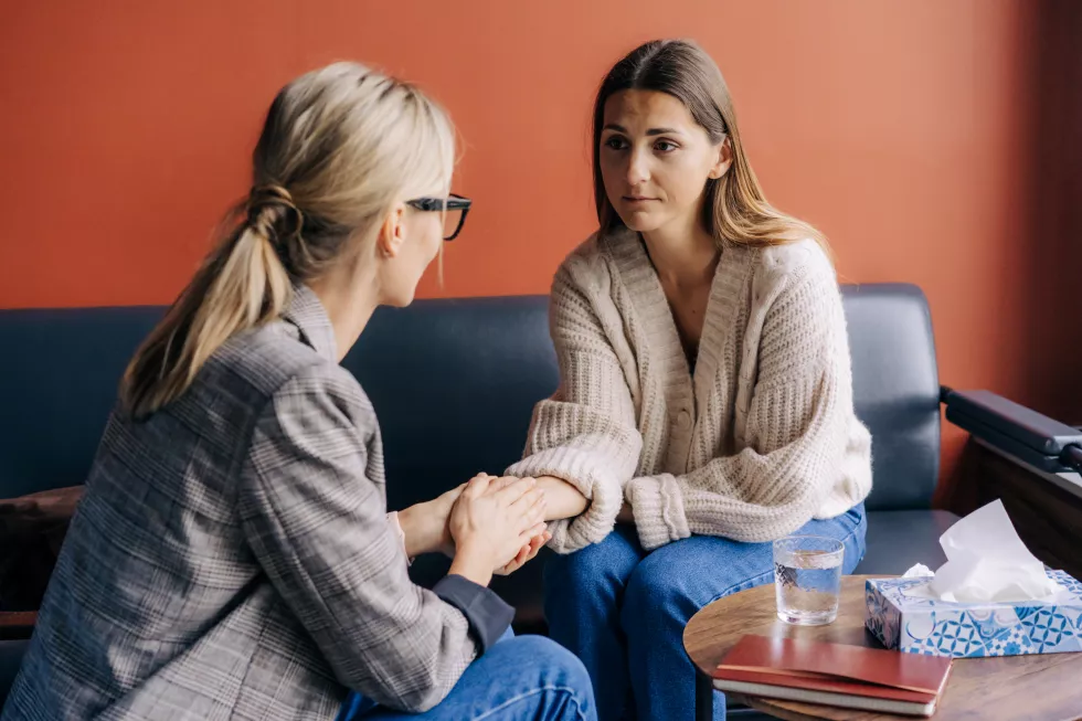 woman-psychotherapist-holding-hand-woman-client-supports-comforts
