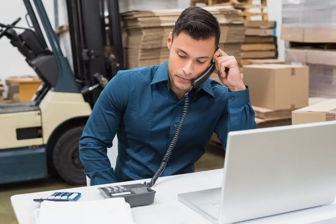 warehouse-manager-using-telephone-laptop