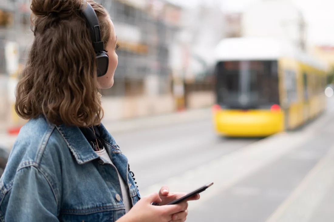 woman-with-headphones-smart-phone-standing-city