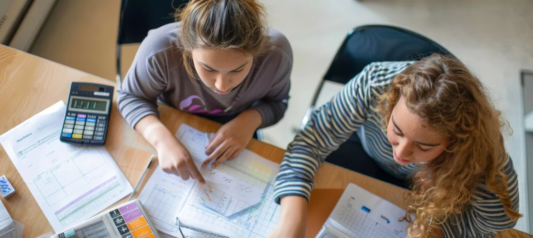 students-collaborating-math-problems-using-calculators-graph-paper-homework