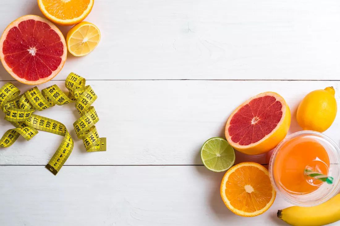 fresh-fruits-with-tape-measure-white-wooden-background-top-view