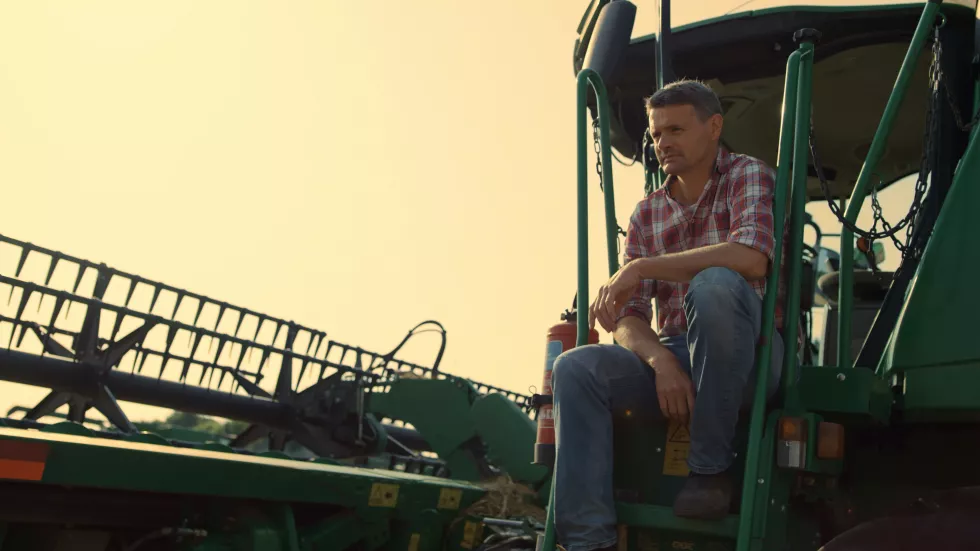 harvester-driver-resting-field-sunlight-farmer-inspecting-cropping-machinery