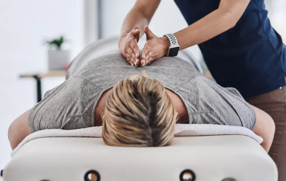 your-back-needs-all-relief-it-can-get-shot-mature-woman-lying-face-down-getting-her-back-massaged-by-physiotherapist-clinic
