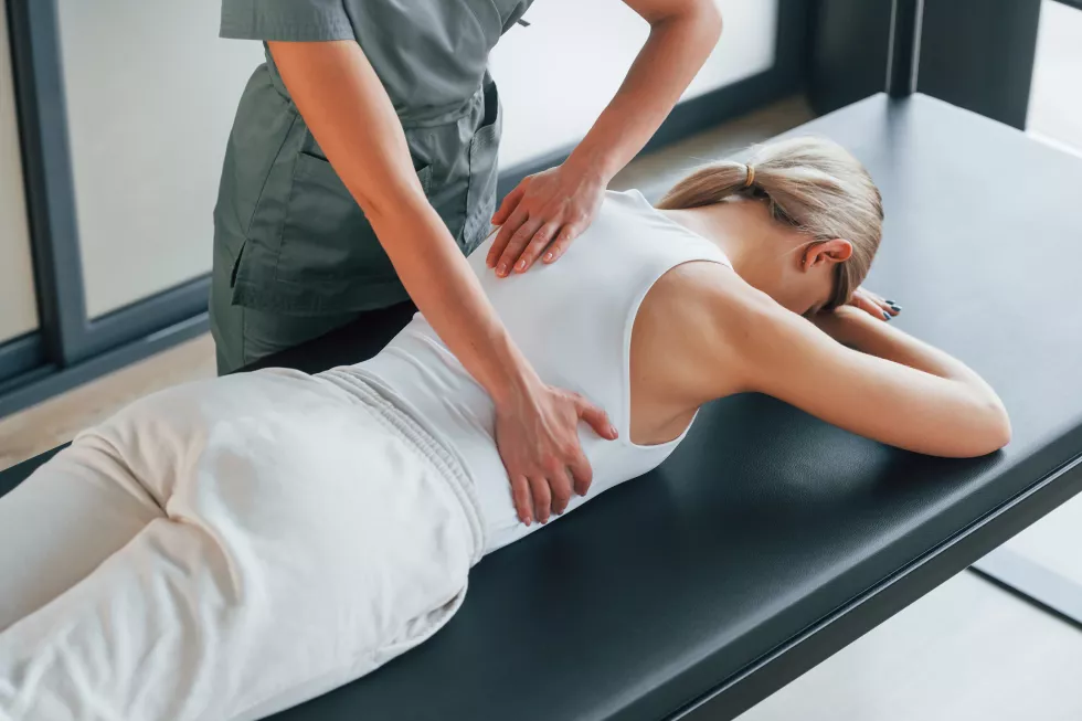 massaging-back-woman-is-health-center-getting-help-by-doctor