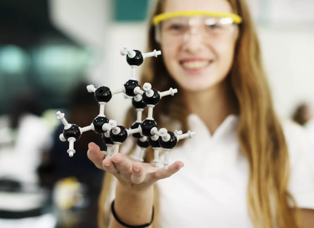 female-student-holding-molecule-model