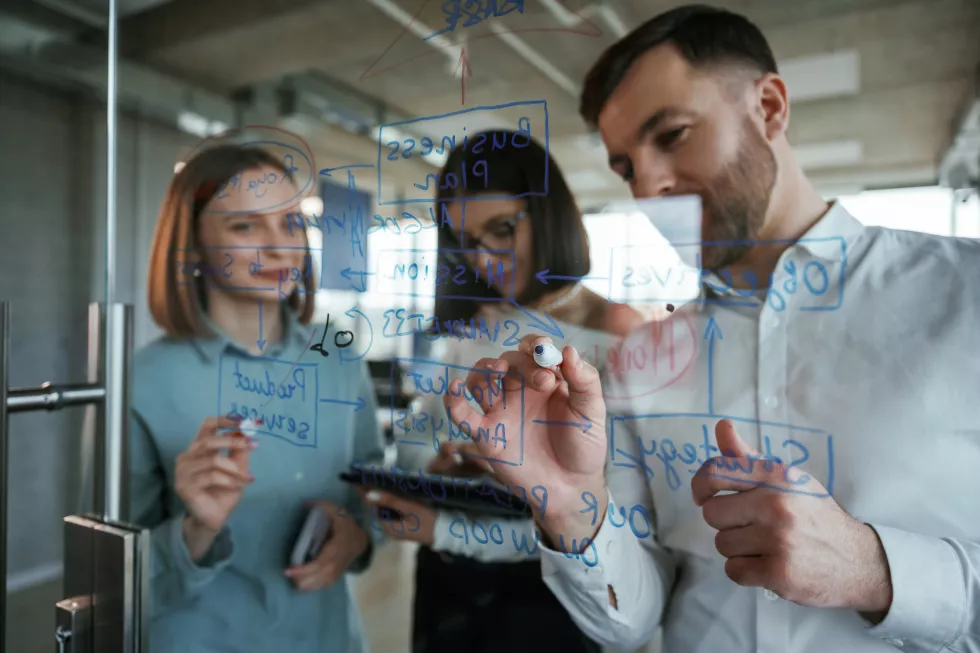 front-view-office-workers-are-creating-plan-standing-by-glass-writing-it
