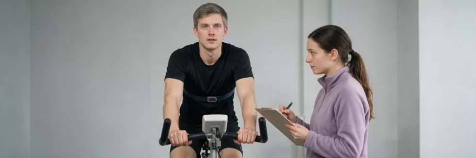 studenci-wychowania-fizycznego-przeprowadzaja-test-wydolnosci-na-rowerku