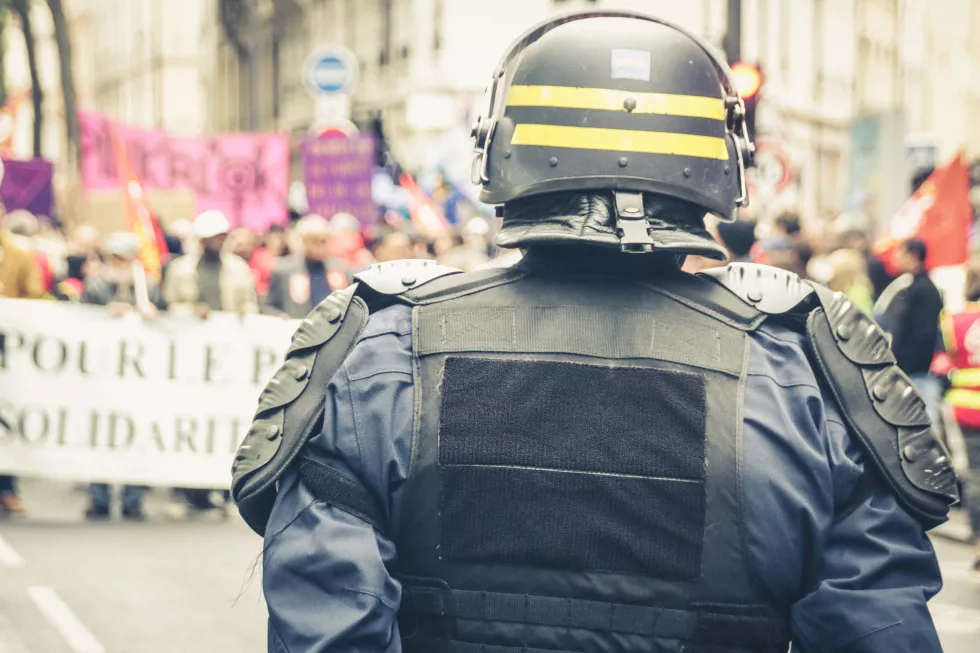 rear-view-policeman-standing-front-demonstration-city