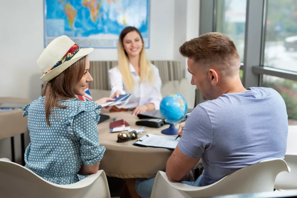 woman-travel-agent-gives-couple-passports-with-plane-tickets-travel-agency