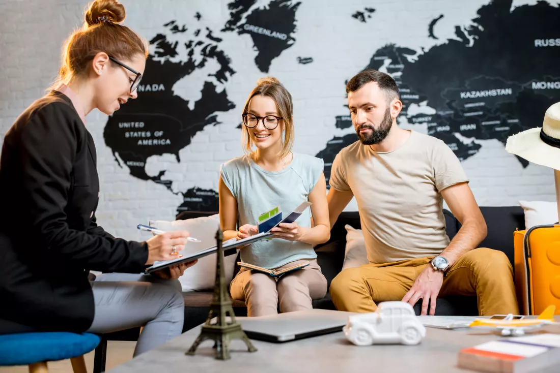 young-lovely-couple-sitting-with-manager-travel-agency-office-prepairing-summer-vacation(1)