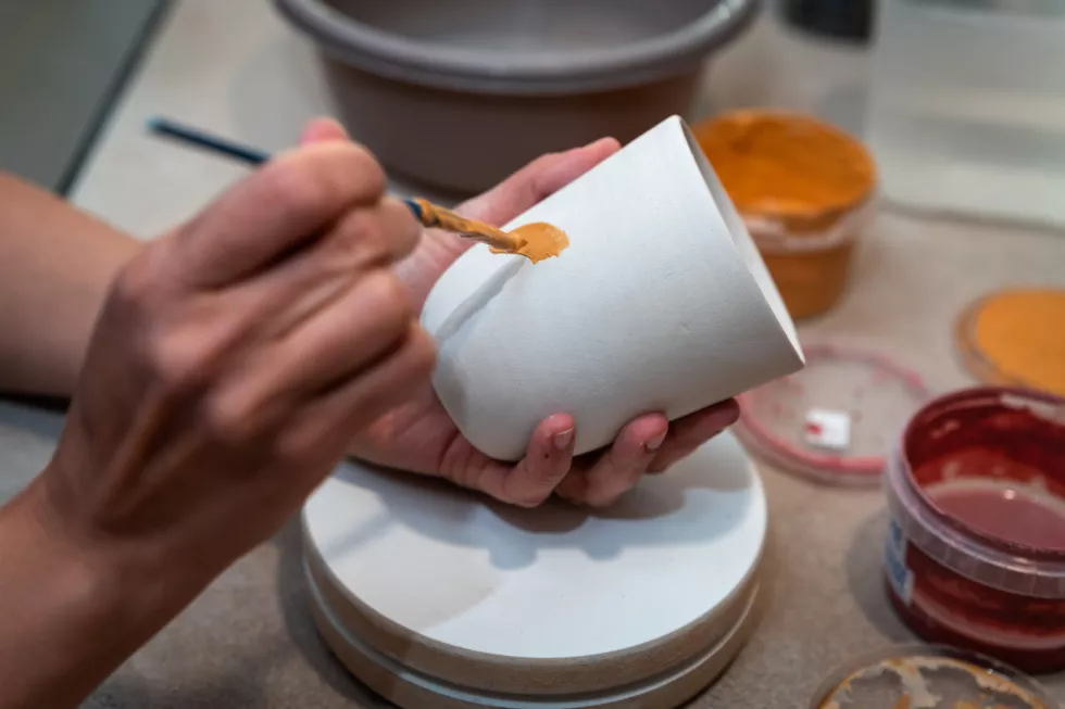 women-s-hands-painting-pottery-object