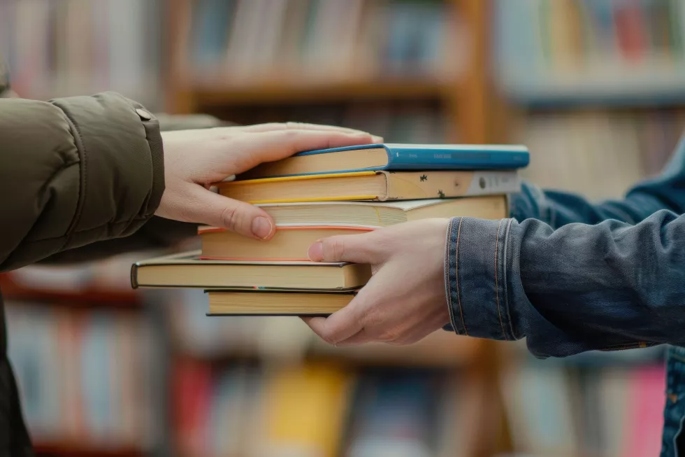 hands-holding-stack-books-front-library-bookshelf-concept-education-reading