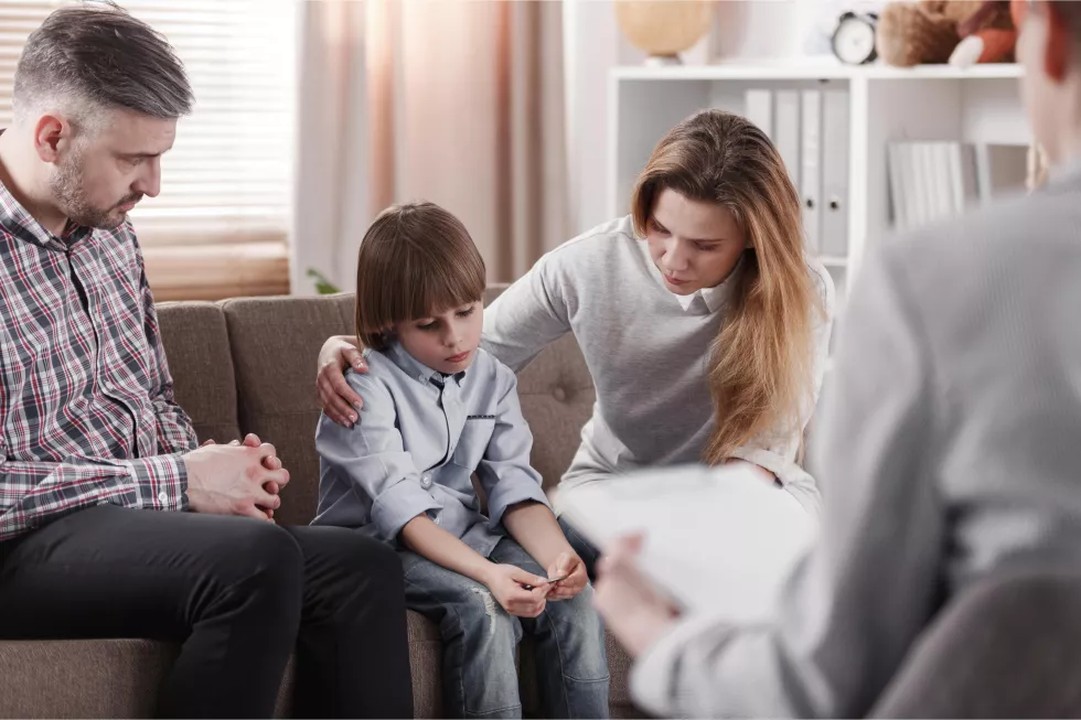 mother-hugging-her-autistic-son-sitting-his-father-family-therapy