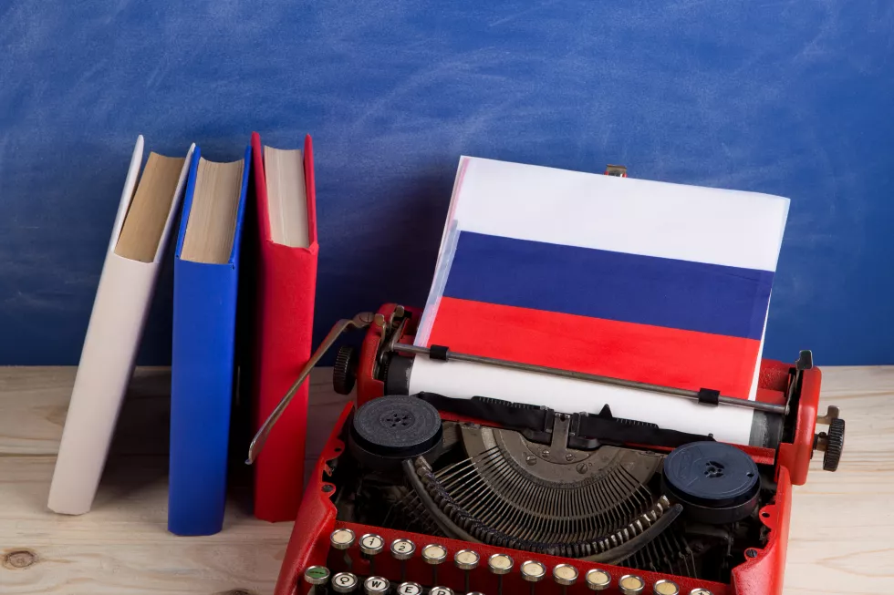political-news-education-concept-red-typewriter-flag-russia-books-table-against-background-blue-school-board