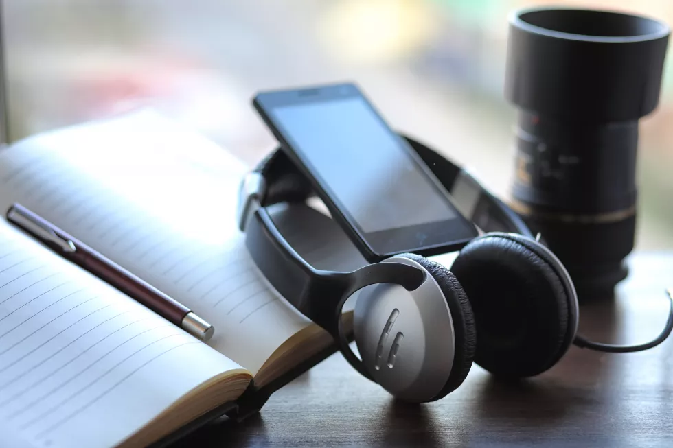 stack-textbooks-with-black-headphones-table