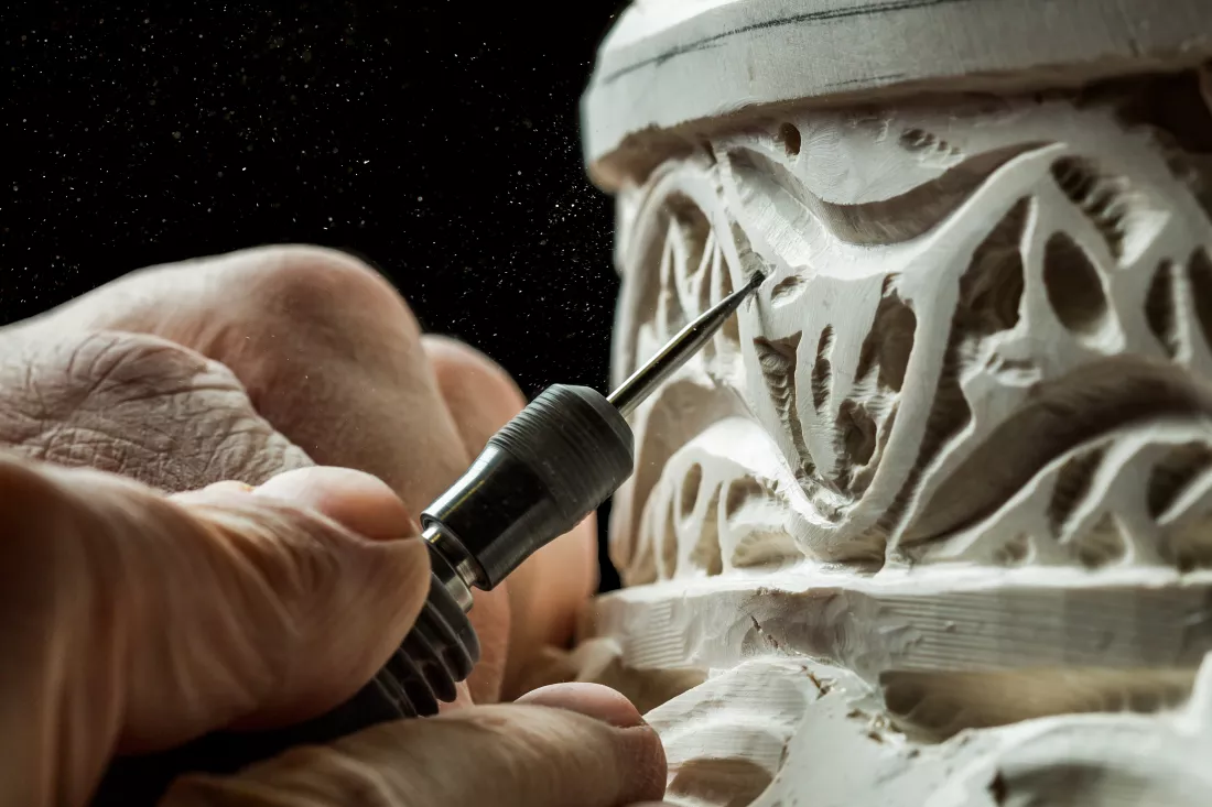 person-hands-carving-ornament-plaster