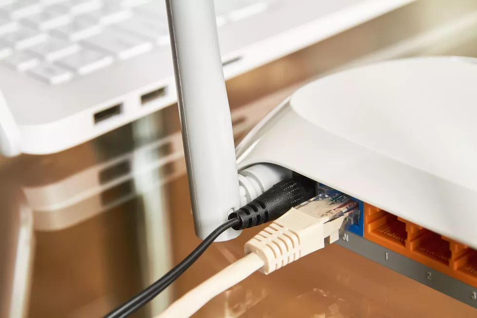 white-wireless-wi-fi-router-near-laptop-glass-table
